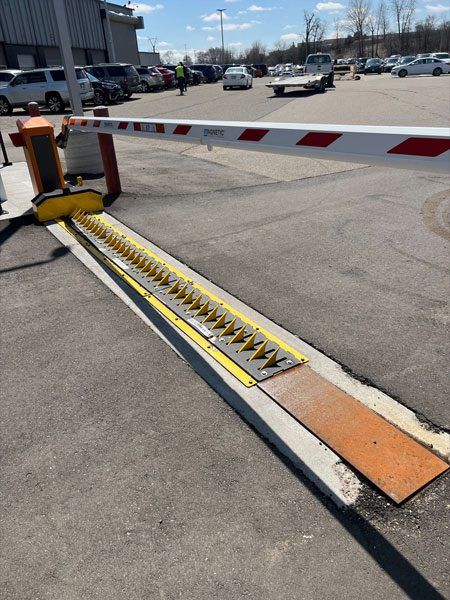 A barrier prevents cars from leaving a parking lot until the attendant lowers the spikes.