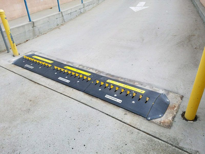 A SM38 Traffic Spike blocks the entrance to a parking lot.