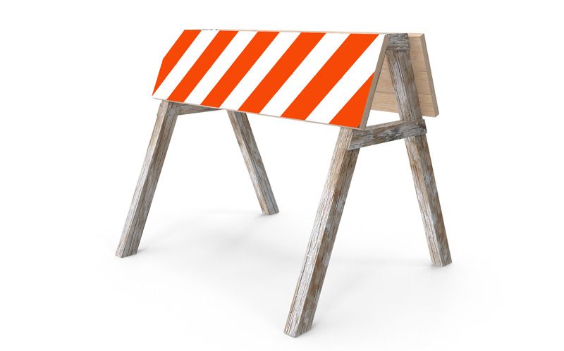 A type 1 road construction barrier sits on a road.
